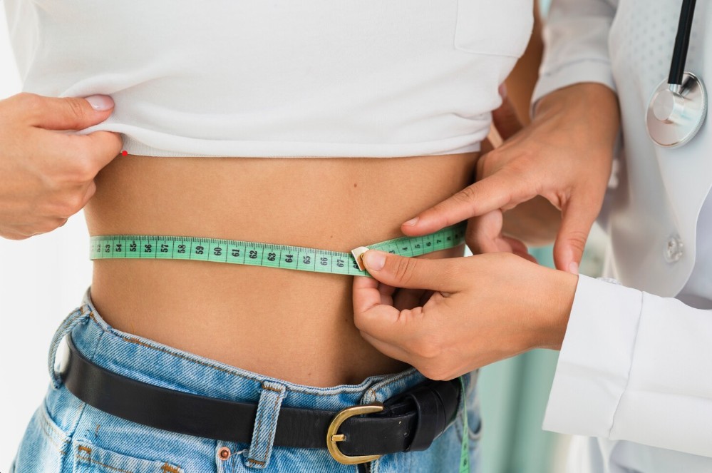 a doctor assisting patient to measure belly size for Non Surgical Fat Reduction in Lakewood Ranch FL